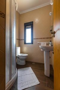 a bathroom with a toilet and a sink and a window at APARTAMENTO BOLONIA SUR B in Tarifa