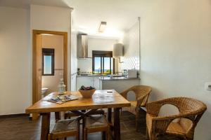 a kitchen with a wooden table and chairs at APARTAMENTO BOLONIA SUR B in Tarifa