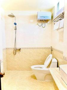 a bathroom with a white toilet and a shower at ELISA HOTEL in Pleiku