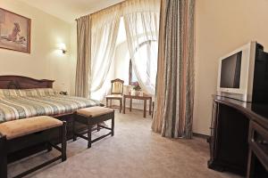 a hotel room with a bed and a television at Гранде Петтине in Odesa
