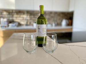 a bottle of wine sitting on a table with two wine glasses at Apartament Blisko Natury in Tomaszkowo