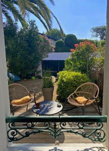 2 chaises et une table sur une terrasse en bois dans l'établissement Xokoan, à Biarritz