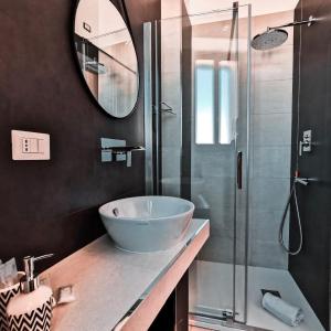 a bathroom with a sink and a glass shower at Il Diamante nei Sassi Rooms in Matera