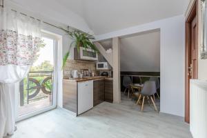 a kitchen with a sliding glass door leading to a balcony at Camelot in Łeba