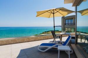 a patio with a table and chairs and an umbrella at Villa Flora in Sozopol