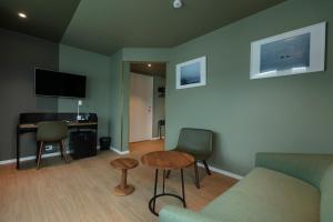 - un salon avec un canapé, une table et un bureau dans l'établissement Maritim Fjordhotel, à Flekkefjord
