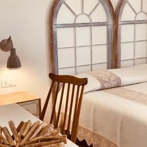 a room with a bed and a chair and a window at B&B Antico Telaio in Santa Maria Navarrese