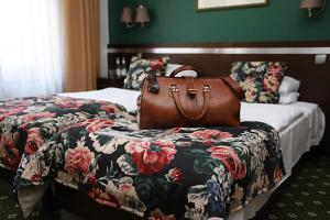 a bag sitting on a bed in a hotel room at Hotel i Restauracja "Pod Orłem" in Kartuzy