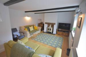 a living room with a couch and a tv at Brook Cottage - Luxury in Mundesley in Mundesley