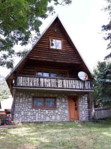 uma pequena casa de pedra com um telhado de gambrel em Chata pod skalou em Haligovce