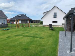 a yard with a playground and a house at Friese24 in Wangerland