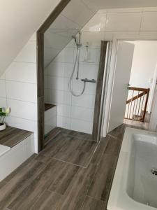 a bathroom with a shower and a bath tub at Friese24 in Wangerland +38 photos