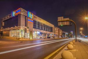 uma rua da cidade à noite com um semáforo e edifícios em Ewaa Express Hotel - Khurais em Riade