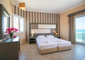 a bedroom with a bed with flowers on it at Aktypis Beachfront Studios in Laganas