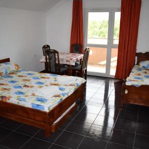 a bedroom with two beds and a table and chairs at Srebrna Nit in Veliko Gradište