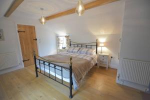 a bedroom with a bed and a wooden floor at Brook Cottage - Luxury in Mundesley in Mundesley