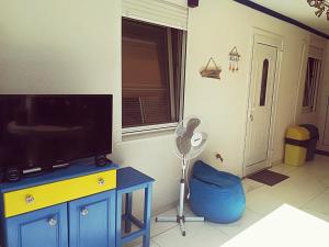 a living room with a flat screen tv and a fan at Villa Blue House in Nea Kallikrateia