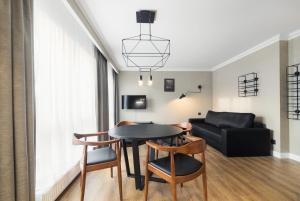 ソポトにあるVictoria Residence Apartments by Grand Apartmentsのリビングルーム(テーブル、椅子、ソファ付)