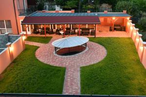 an outdoor patio with an umbrella in the grass at Hotel Barbakán in Pécs