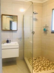 Cape Town的住宿－Authentic Newlands，一间带玻璃淋浴和水槽的浴室
