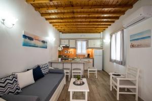 a living room with a couch and a kitchen at Filoxenia Apartments in Ornos