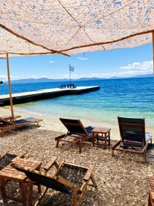 a group of chairs and tables on a beach at Pegasus Hotel & Coastal Cafe in Kala Nera