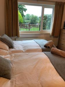 a bedroom with a large bed with a window at Merok Lodge in Great Eccleston