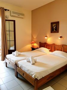 2 camas individuales en una habitación con ventana en Pegasus Hotel & Coastal Cafe, en Kala Nera