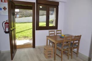 ein Esszimmer mit einem Tisch, Stühlen und einem Fenster in der Unterkunft Albergue Cascoxu 