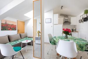 Apartment & rooms Ivica في كرك: غرفة معيشة مع طاولة وكراسي بيضاء