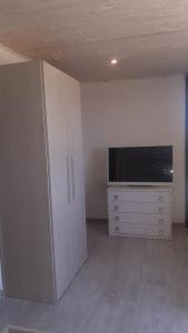 ein Wohnzimmer mit einem TV und einem Schrank in der Unterkunft Casa vacanza salento GiovAsia in Sannicola