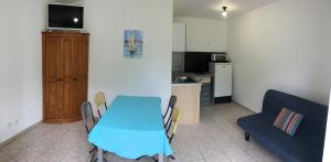 une cuisine avec une table bleue, des chaises et un canapé dans l'établissement Le Mas des 3 Anes, à Blars 30 autres photos