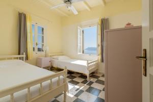 a bedroom with two beds and a window at Kimolian Houses in Kimolos