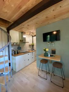 a kitchen with a table and two stools at Petit Maison du Chêne in Auriac-du-Périgord
