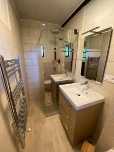 a bathroom with two sinks and a mirror at Petit Maison du Chêne in Auriac-du-Périgord