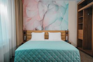 a bedroom with a bed with a painting on the wall at Vozdvizhenskoe Park Hotel in Serpukhov