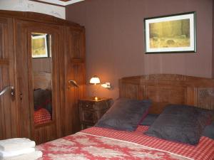1 dormitorio con 1 cama, armario y ventana en Les chambres d'hotes du cosquer, en Beuzec-Cap-Sizun