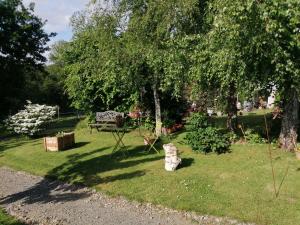 a park with a bench and some trees and grass at Maison d'hôtes Les Vallées in Saint-Quentin-sur-le-Homme