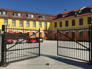 a gate in front of a yellow building at Penzión RESA in Spišská Nová Ves