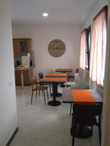 una habitación con mesas y sillas y una cocina en B&B NONO TILIO, en Talmassons