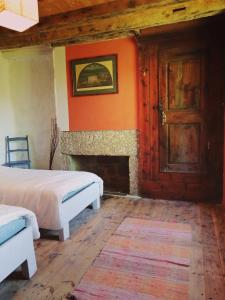 1 Schlafzimmer mit 2 Betten und einem Kamin in der Unterkunft La Ferme du Crouzet in Rimeize