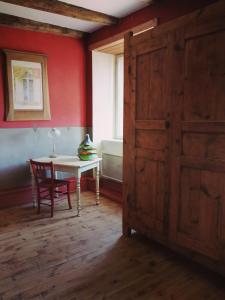 um quarto com uma mesa, uma janela e uma porta em La Ferme du Crouzet em Rimeize