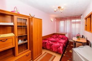 a bedroom with a red bed and a wooden cabinet at Orchideia Studios in Sandanski