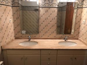 uma casa de banho com dois lavatórios e dois espelhos em Casa Oliván em Graus