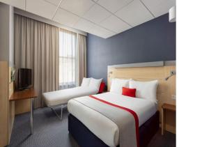 ein Hotelzimmer mit einem großen Bett und einem TV in der Unterkunft Holiday Inn Express Edinburgh City Centre, an IHG Hotel in Edinburgh