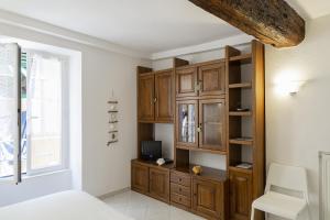 1 dormitorio con armarios de madera y TV. en Appartamento nel centro di Camogli by Wonderful Italy, en Camogli