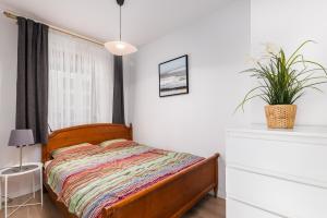 sypialnia z łóżkiem i doniczką w obiekcie BG Apartments Grzybowska w Warszawie