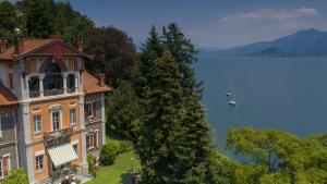 a large house on a hill next to a body of water at Villa Selva Luxury Lakeview Apartment in Ghiffa