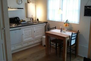 a kitchen with a table and a sink and a counter at Omas kleine huisje in Veere