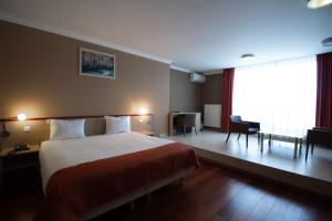 a hotel room with a large bed and a desk at Hotel Taormina Brussels Airport in Zaventem